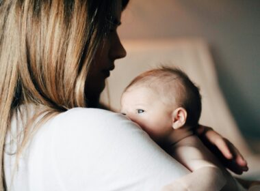 woman in white shirt carrying baby